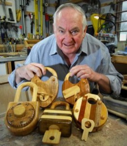 Locksmith smiling and holding wooden locks and wooden keys