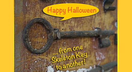 Rusted Old Skeleton Keys Hung Up Against a Wall with "Happy Halloween, from One Skeleton Key to Another" Text Overlay