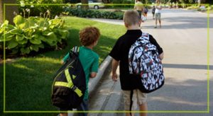 two children with large backpacks walking side by side