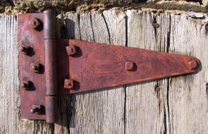 A rusty hinge on an outdoor fence