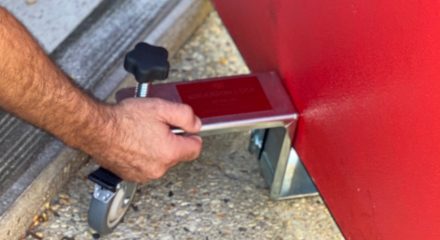Close on man using door stud to install red door