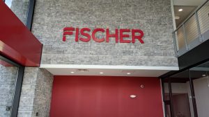 Low angle on gray interior wall that says Fischer