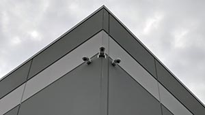 Low angle on three cameras mounted on exterior corner of building