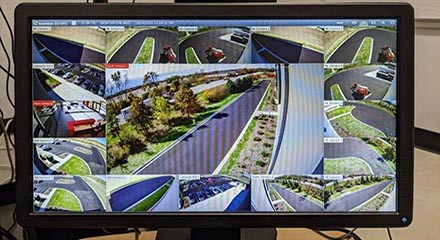 Computer monitor displaying security cameras of parking lot and roads around building